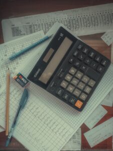 a calculator sitting on top of a pile of papers